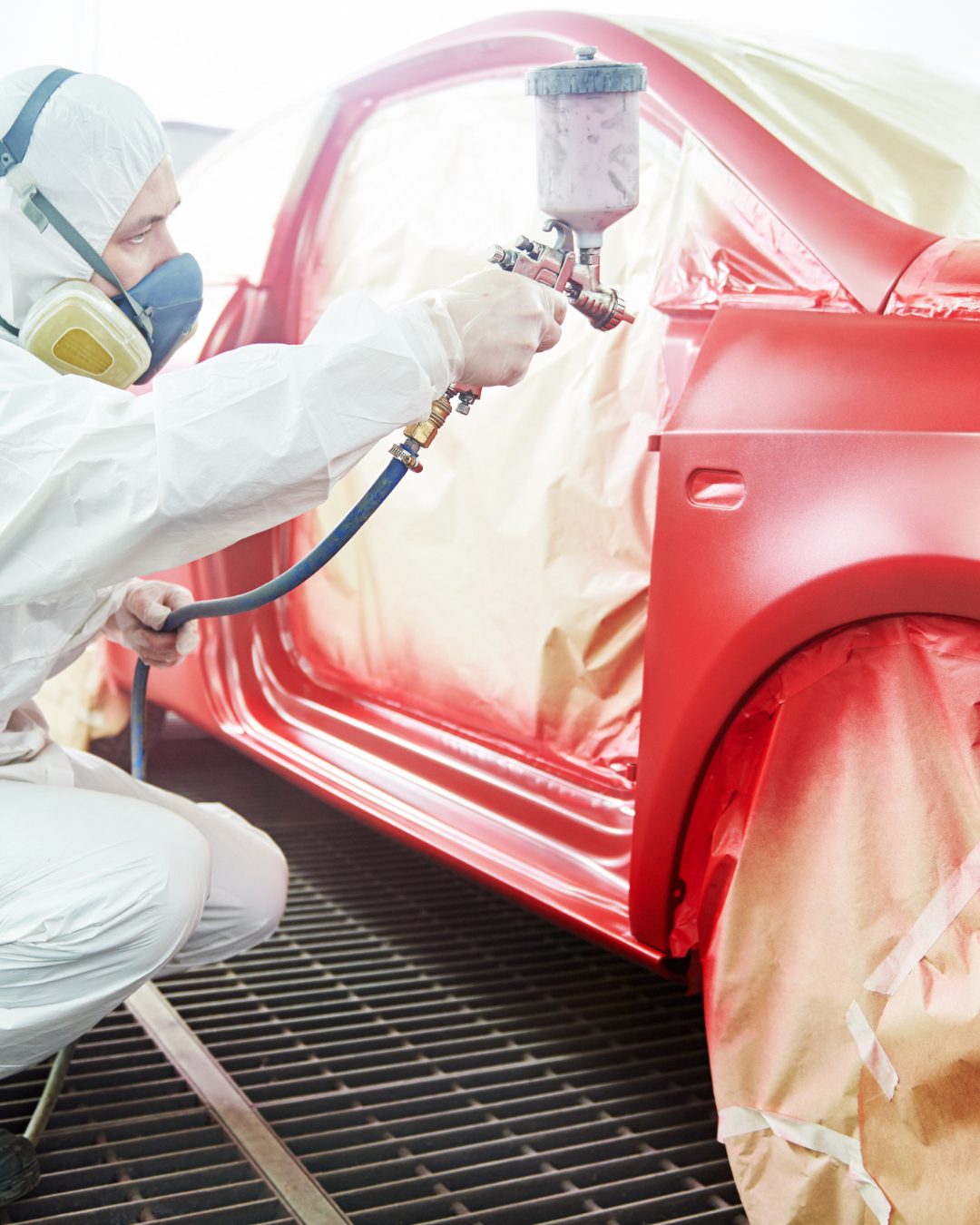 Technician spraying car panel